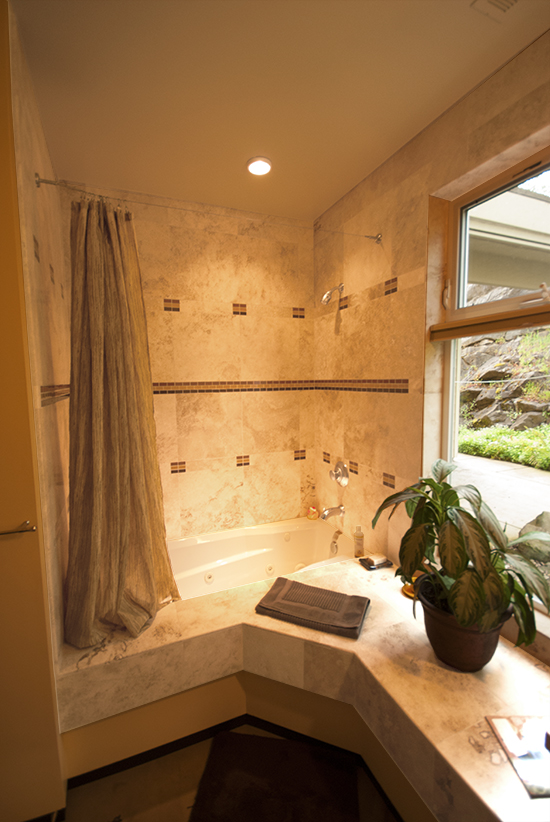 bathroom with Travertine tile and jetted bathtub